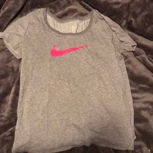 A short sleeve Nike shirt with a pink logo